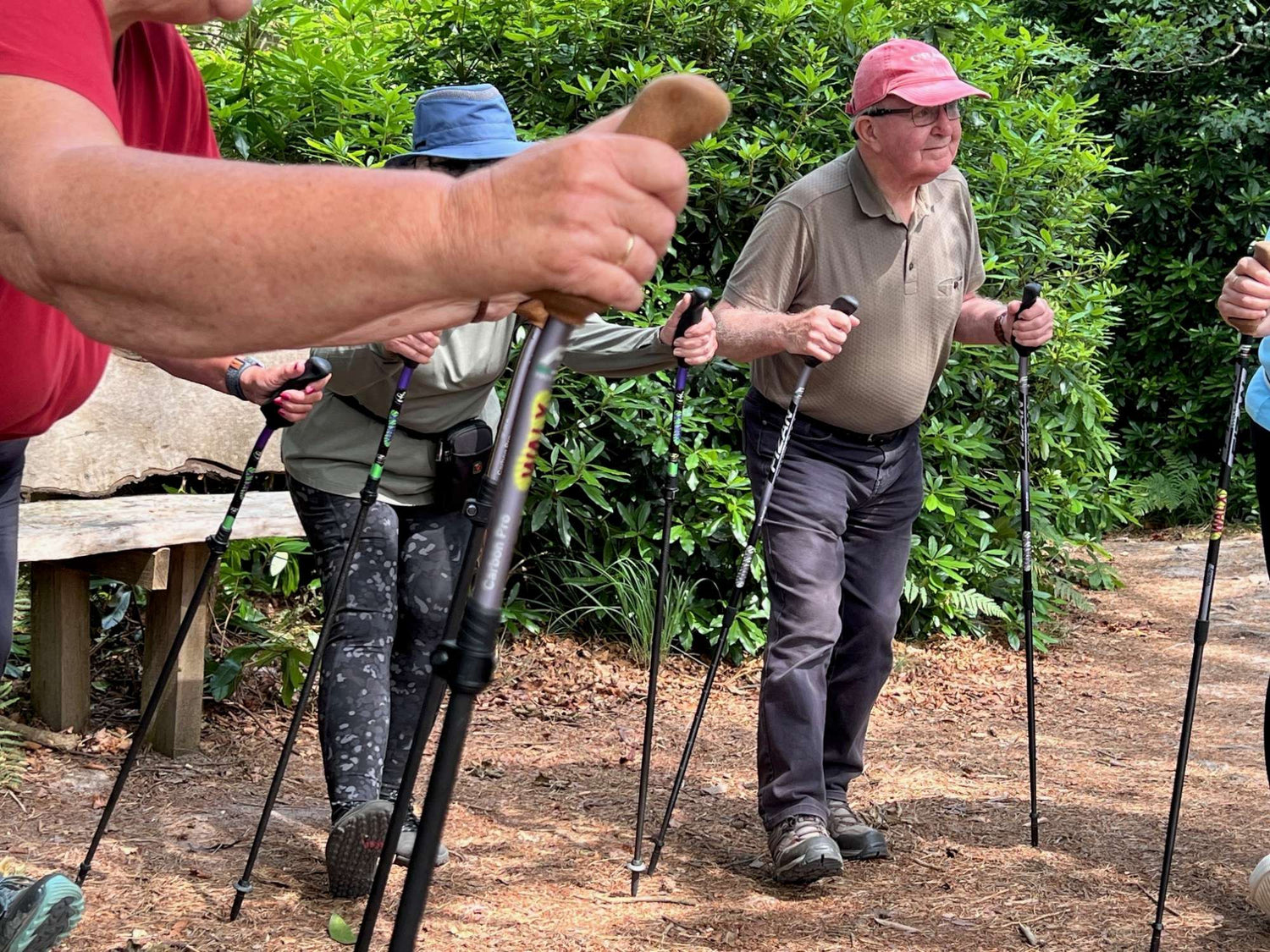 Group of people using WALX Walking sticks outdoors with greenery in the background