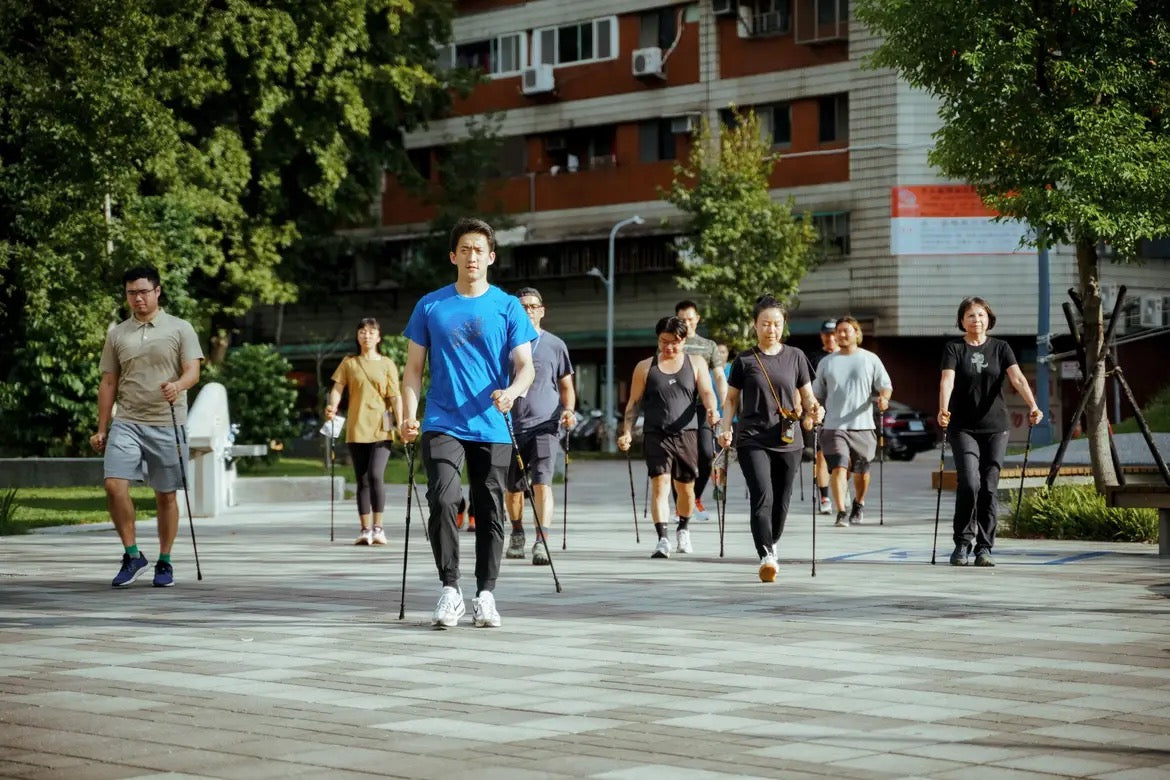 Group of people using WALX Total Body Walking Poles in an urban environment