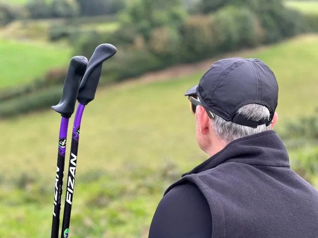 Man holding WALX poles with a blurred natural background